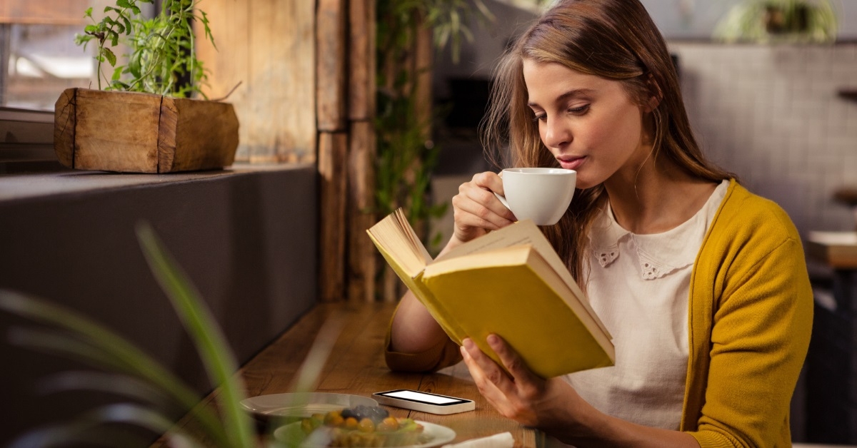 woman enjoying coffee while reading book