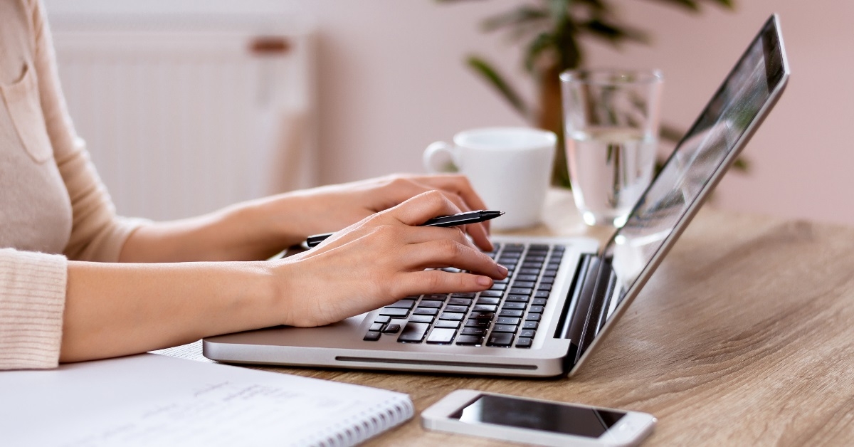 woman typing on laptop at table