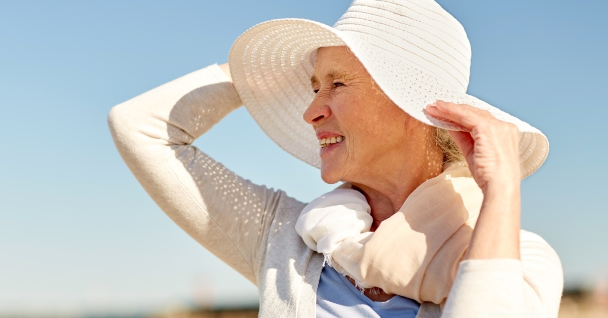senior woman wearing hat on beach