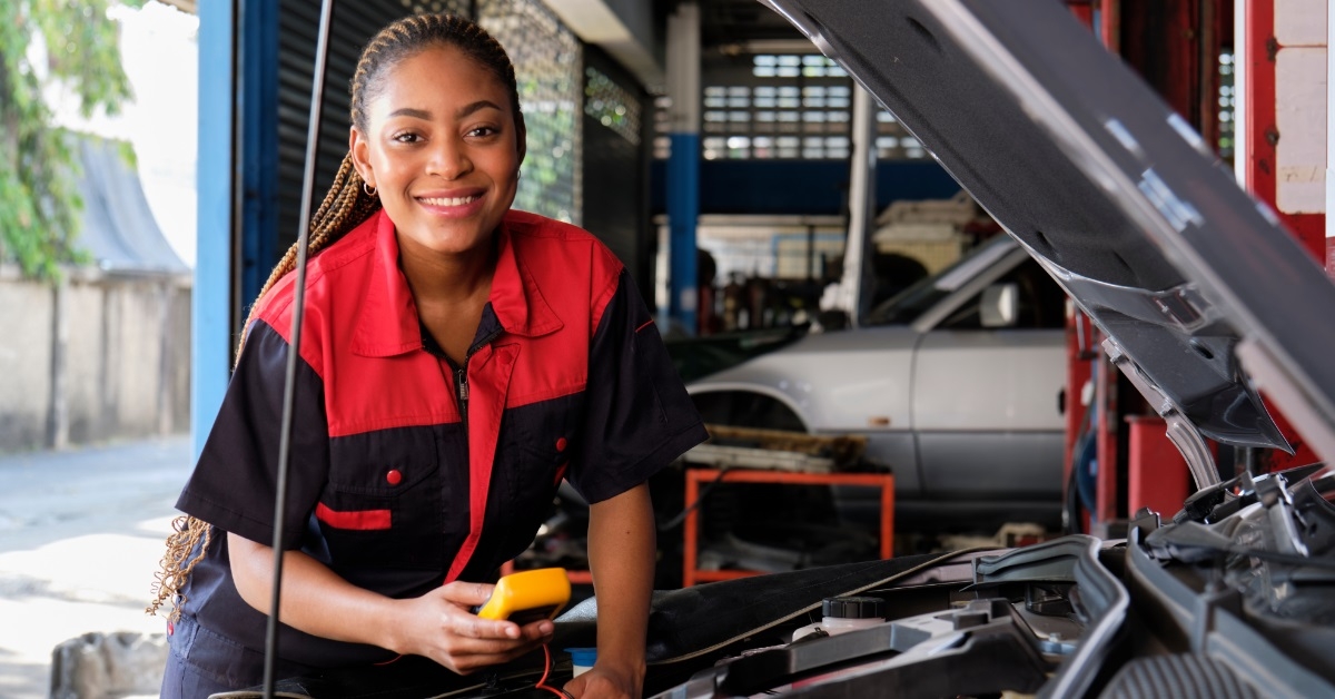 female mechanic checking electric car battery