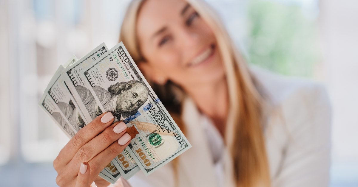 happy woman flaunting banknotes in hand