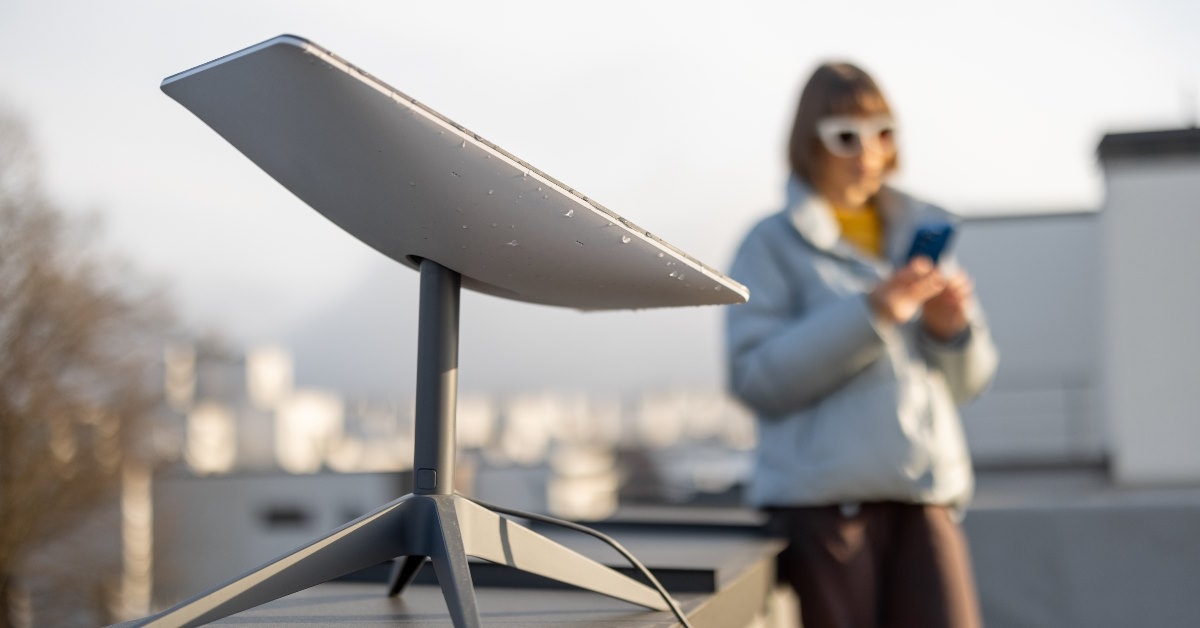 woman standing besides starlink satellite internet