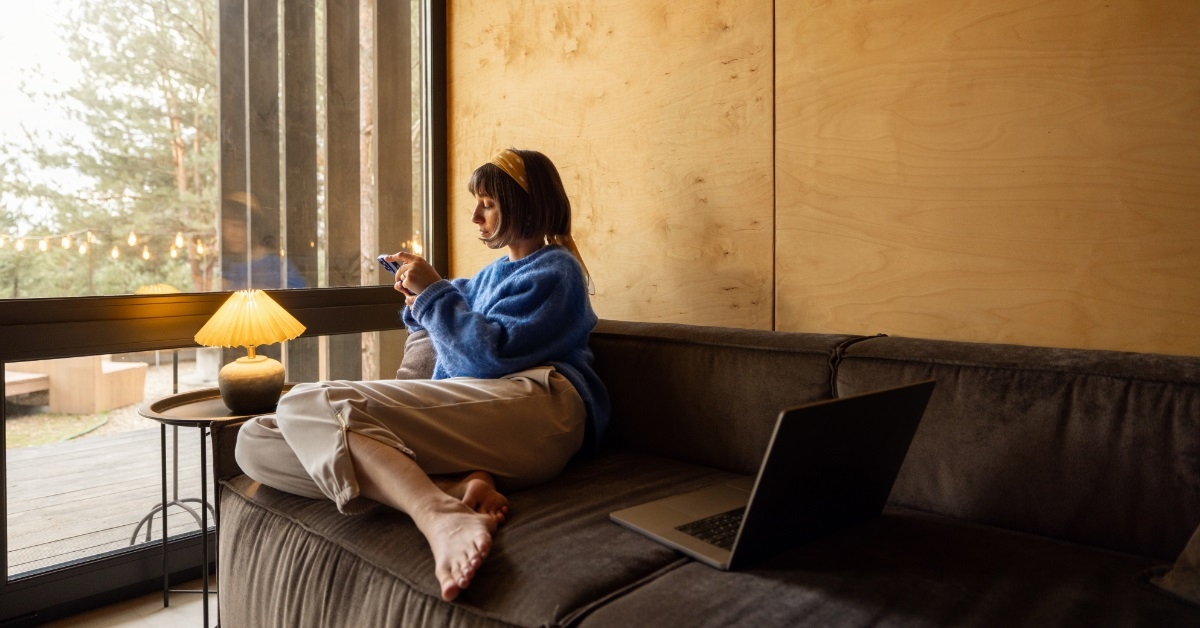 woman using Smartphone on cozy couch