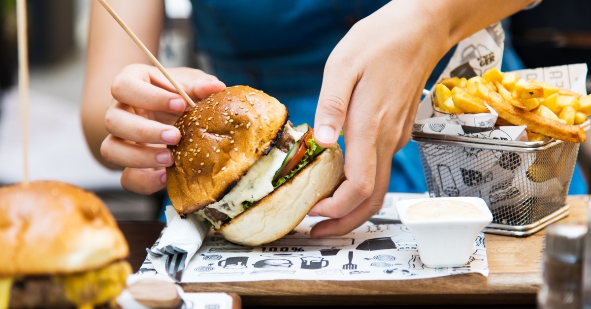 girl eating burger with fries
