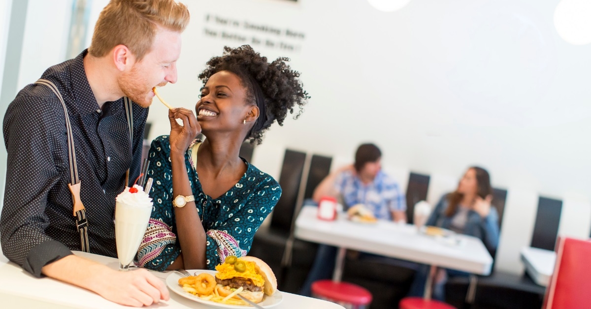 girlfriend feeding fries to boyfriend