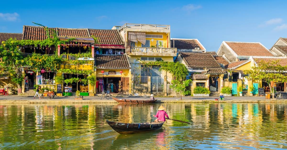 Woman crossing a river on a boat in Hoi An during mid day