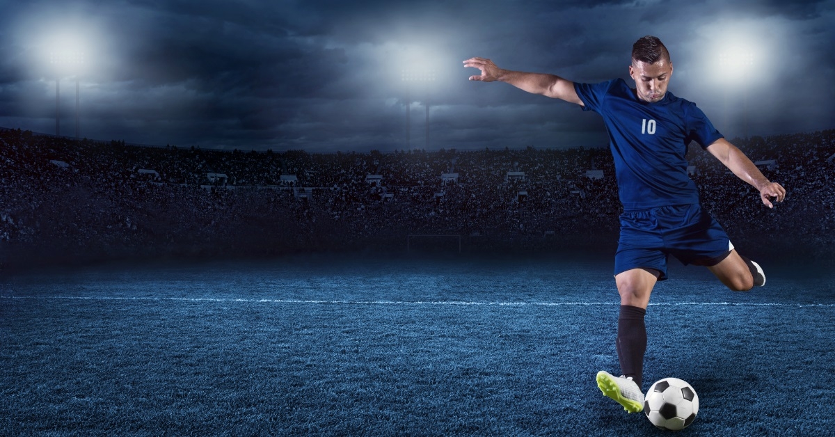 soccer player playing at crowded stadium
