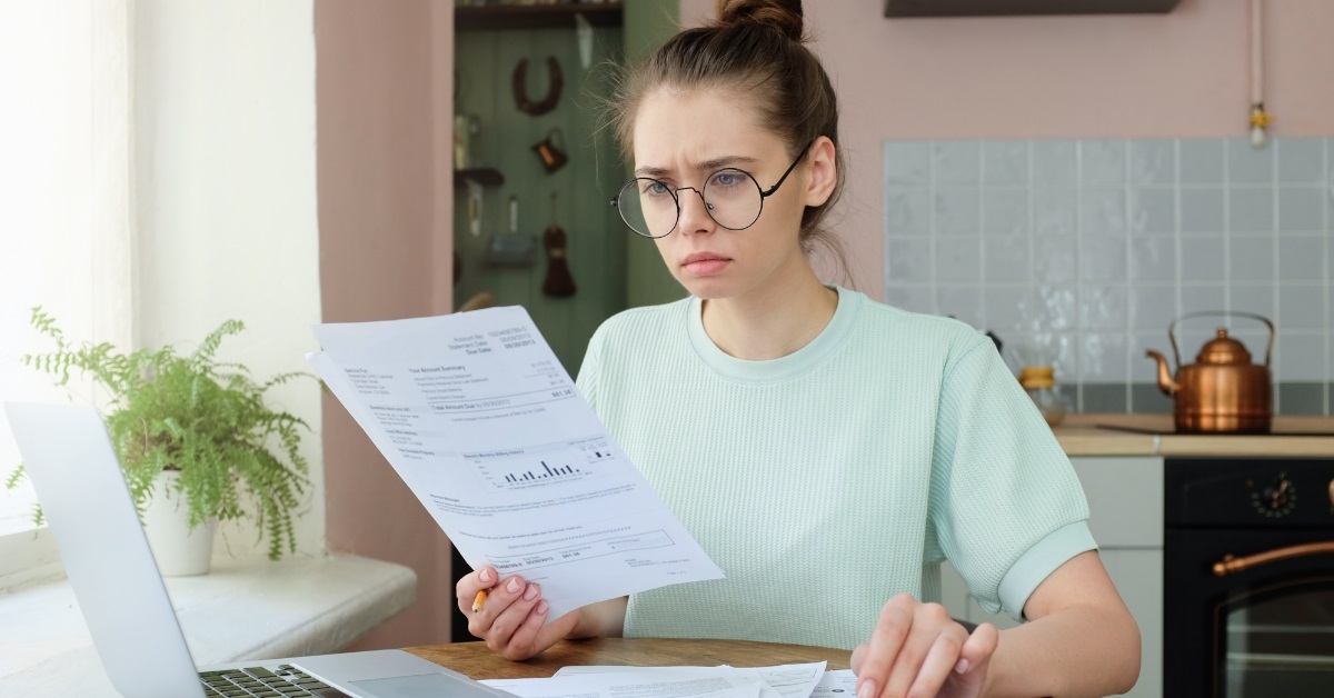 woman reviewing bills at kitchen table