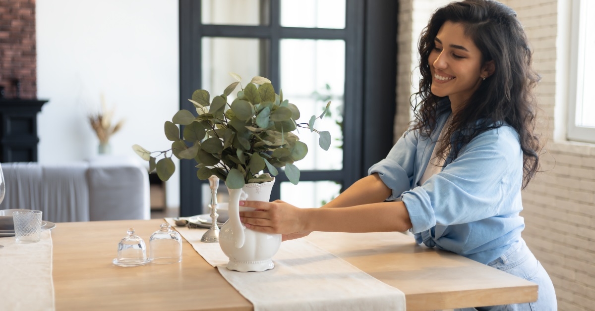 woman arranging vase on table