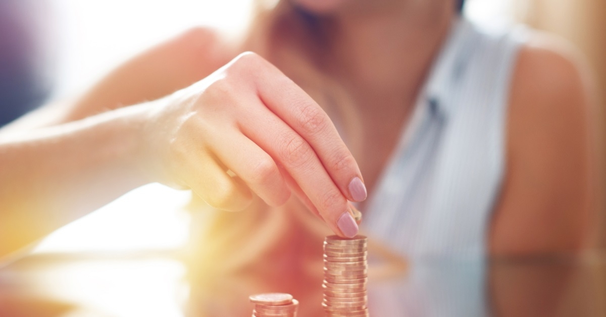woman stacking coins on table