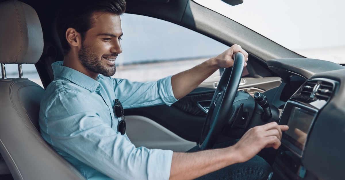 young man driving car on road