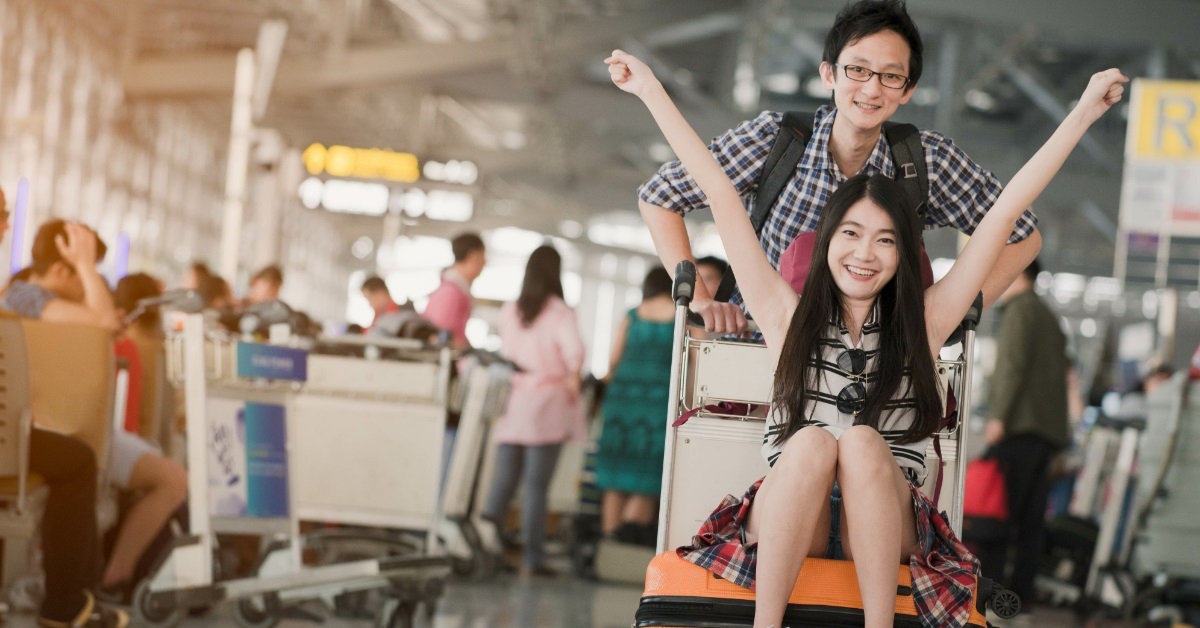 asian couple with luggage at airport