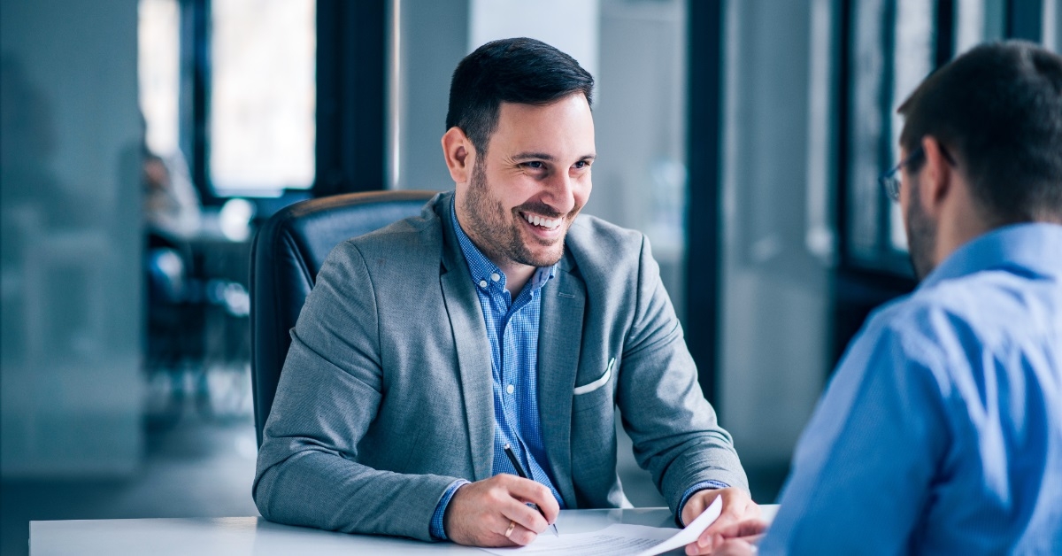man signing contract with estate agent