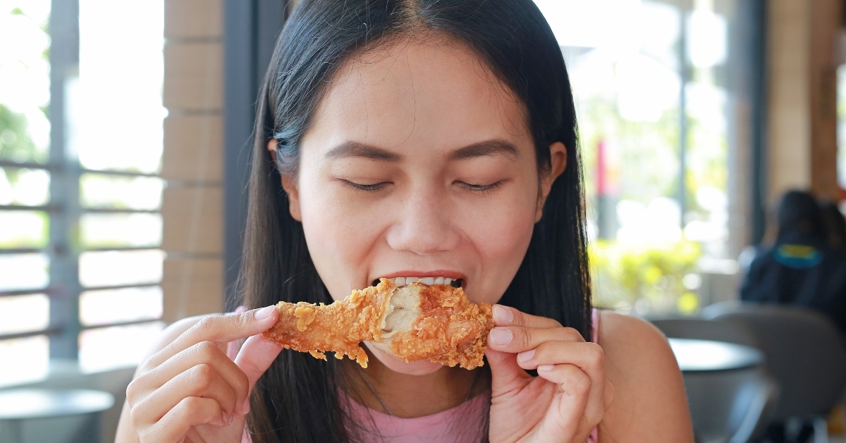 asian woman eating fried chicken