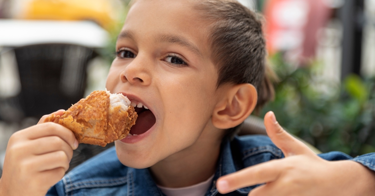 boy eats fried chicken