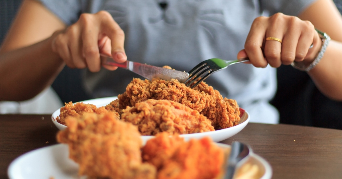 woman cutting fried chicken