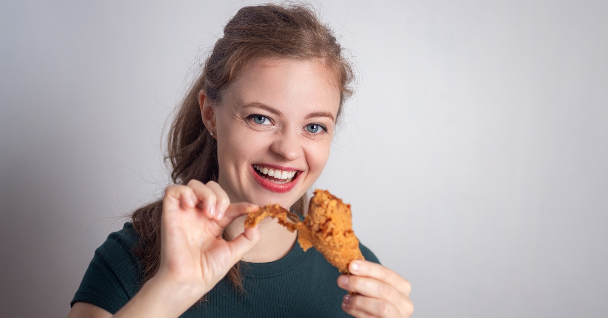 holding eating fried chicken drumstick
