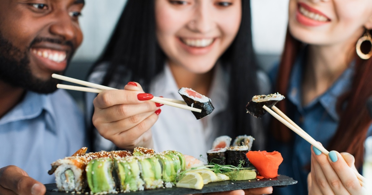 multi ethnic friends eating sushi