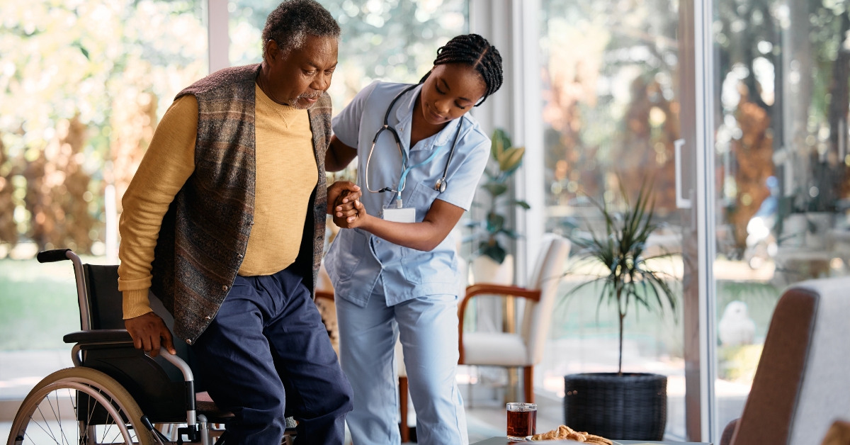 black nurse assists senior man