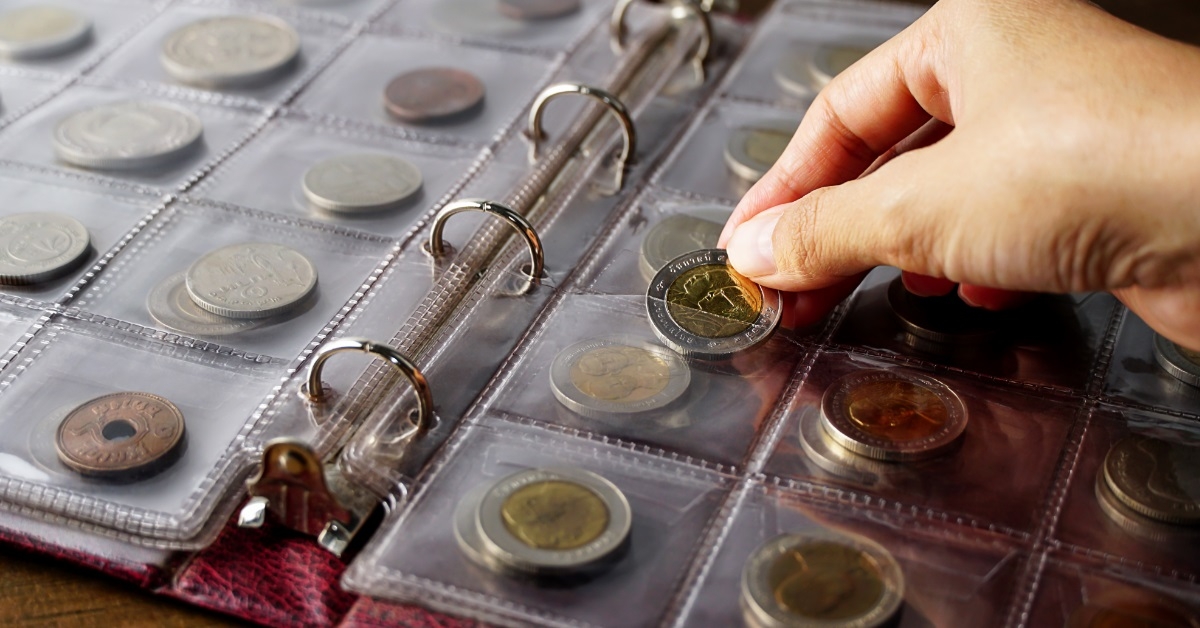 man collecting coins in album