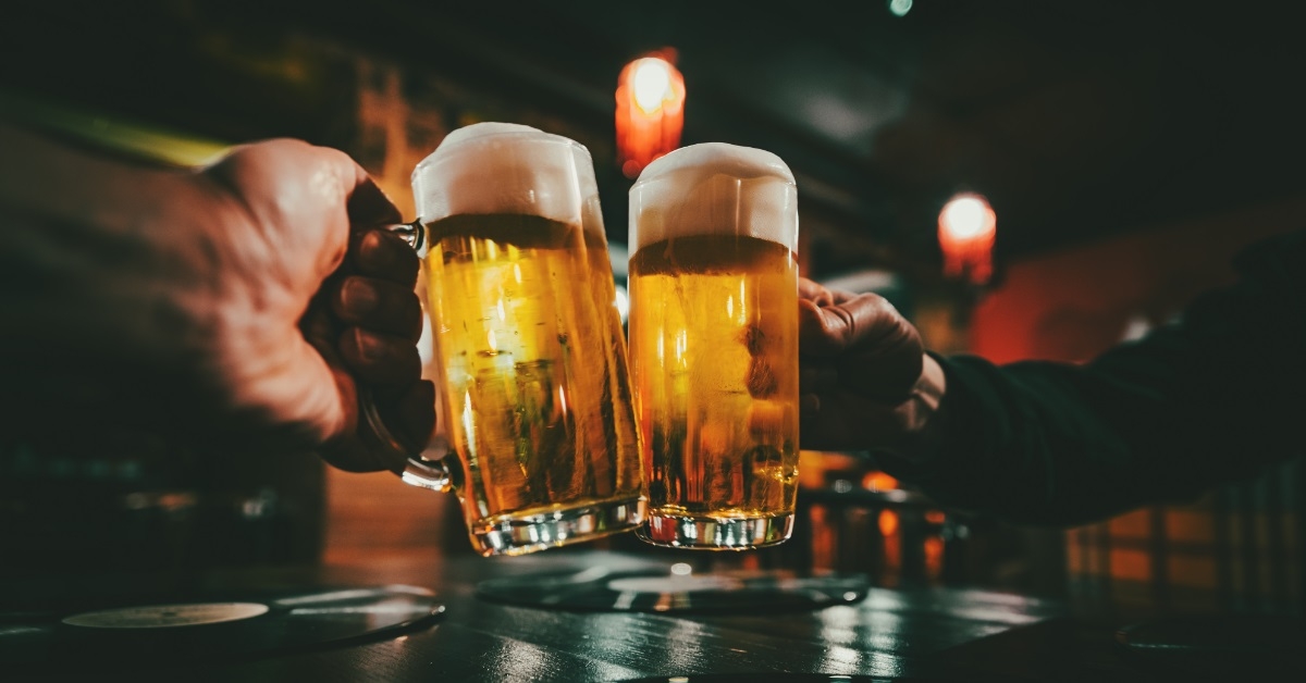 men clinking beer glasses with foam