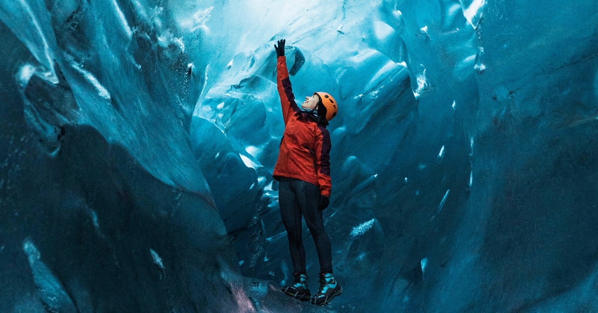 excited female tourist exploring ice cave