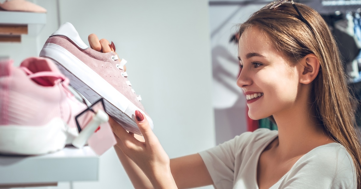 happy woman buying sneakers at store