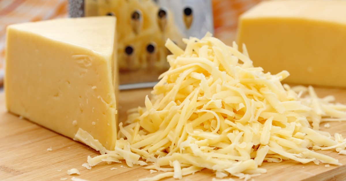 pile of grated cheese on cutting board