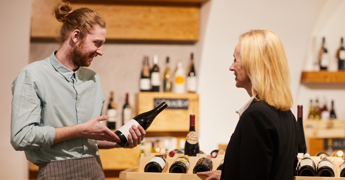 salesman consulting customer in liquor store