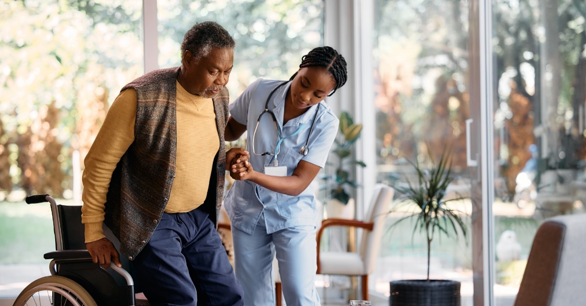 african american nurse helping patient walk