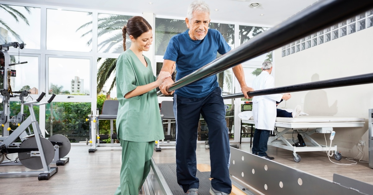 female physiotherapist helping senior patient walk
