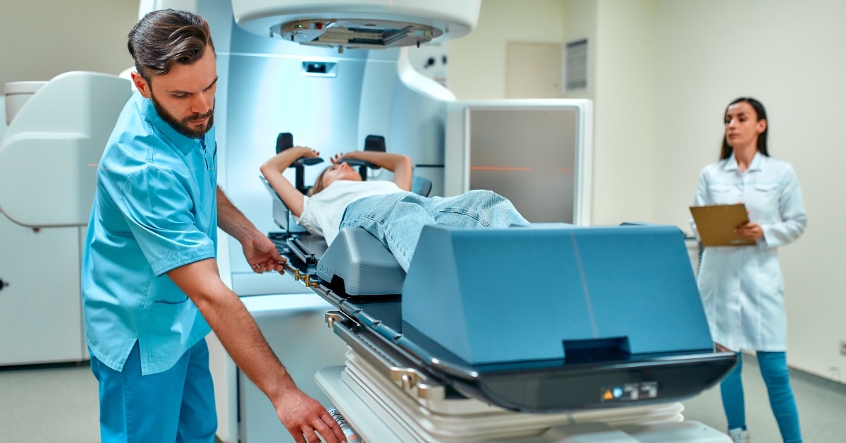 woman undergoing radiation therapy besides nurses