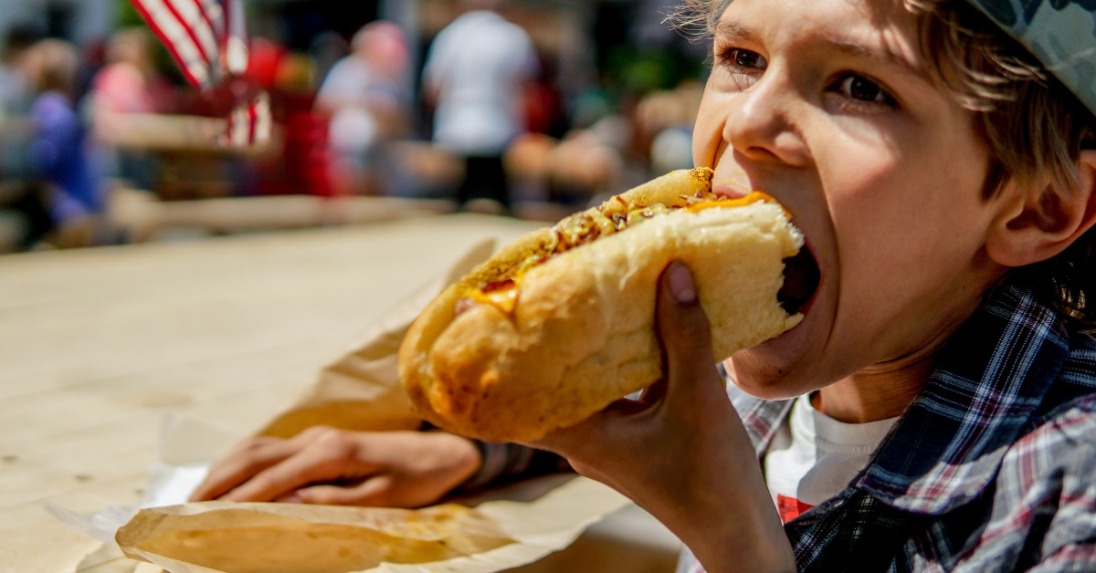 Boy eating barbecue grilled hot dog