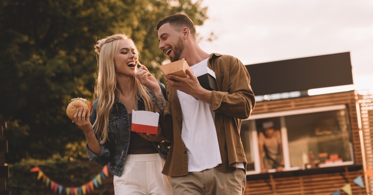 couple eating fries near food truck