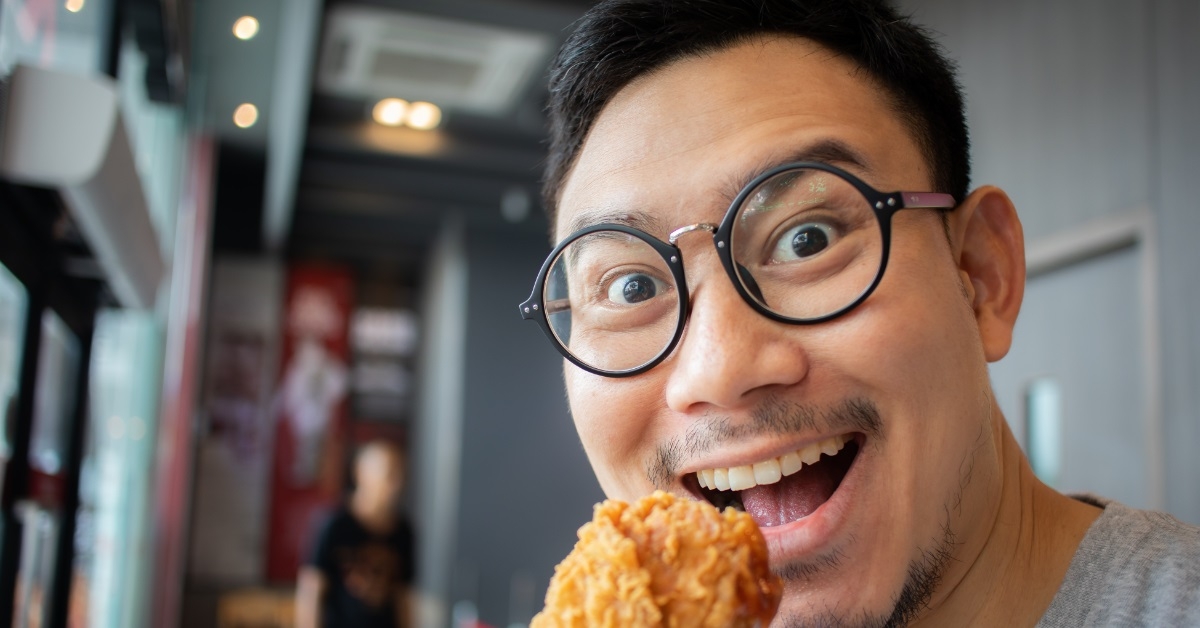 man eating fried chicken at restaurant