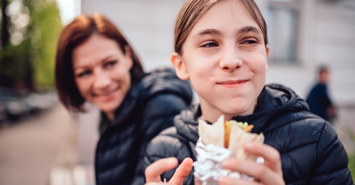 mother daughter eating food on street
