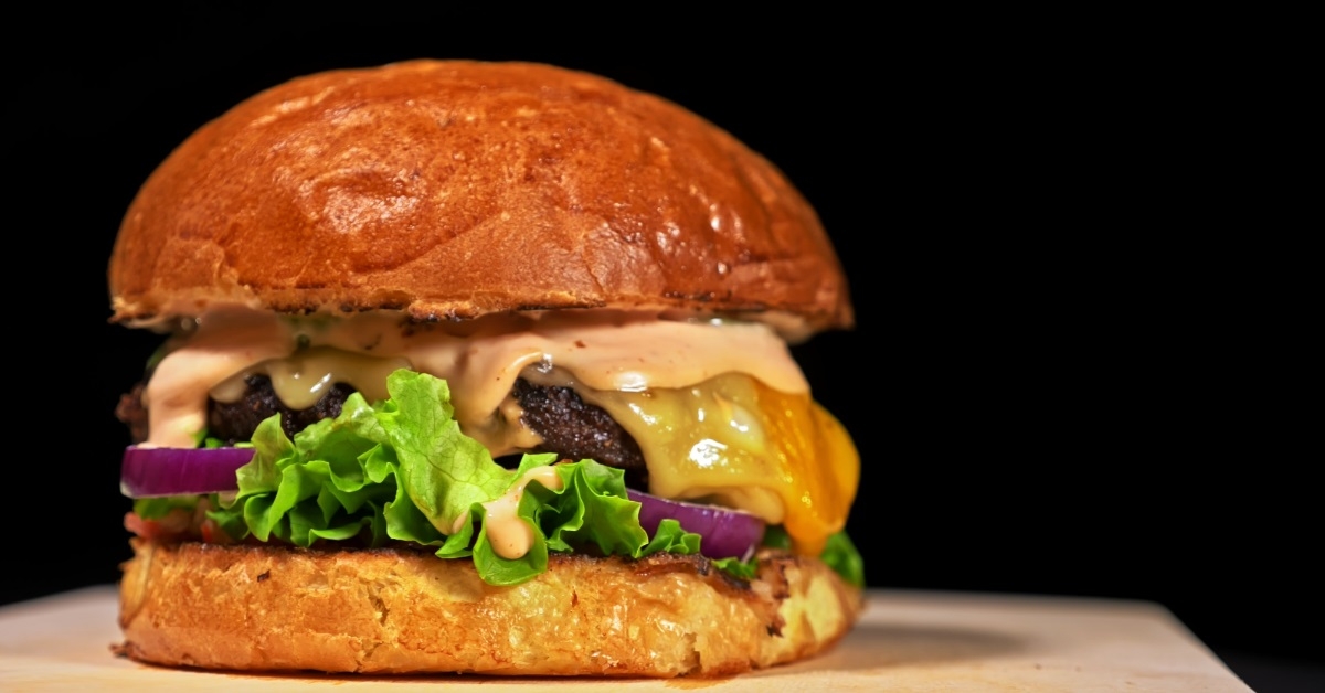 saucy burger on wooden board