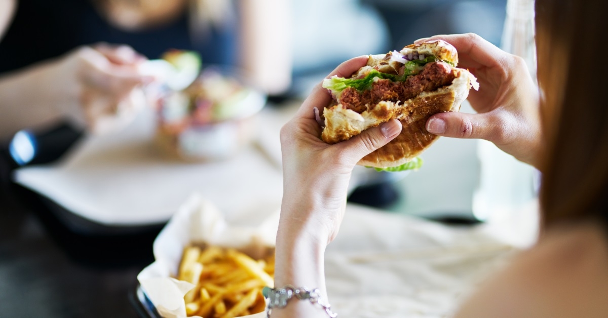 woman eating vegan meatless burger