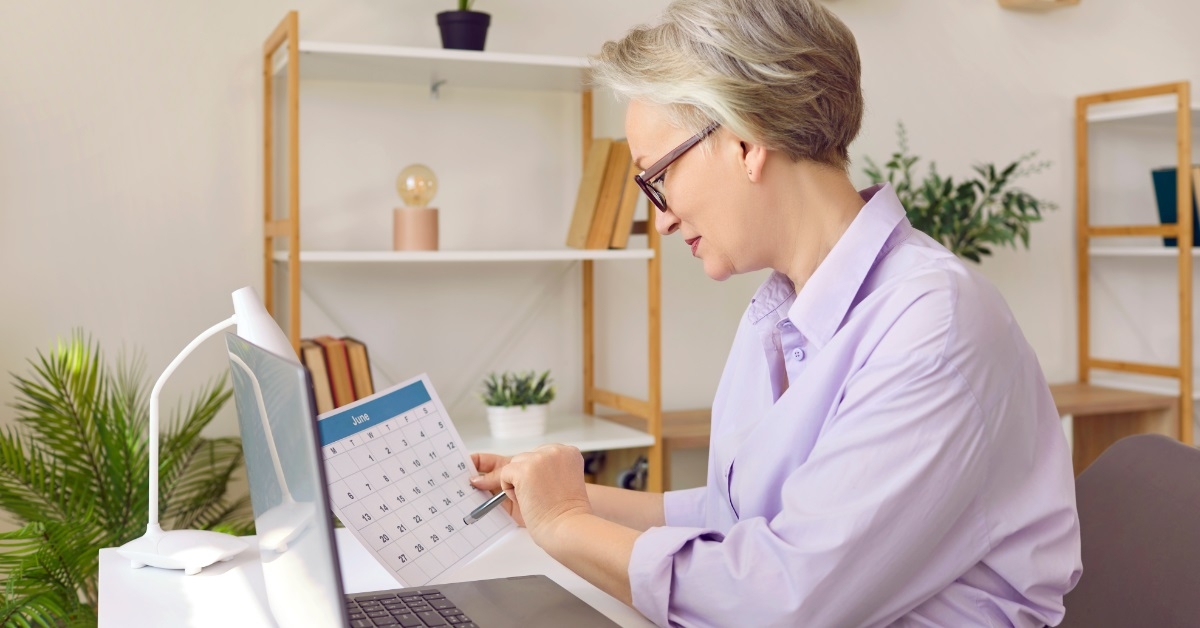senior business woman reviewing paper calendar