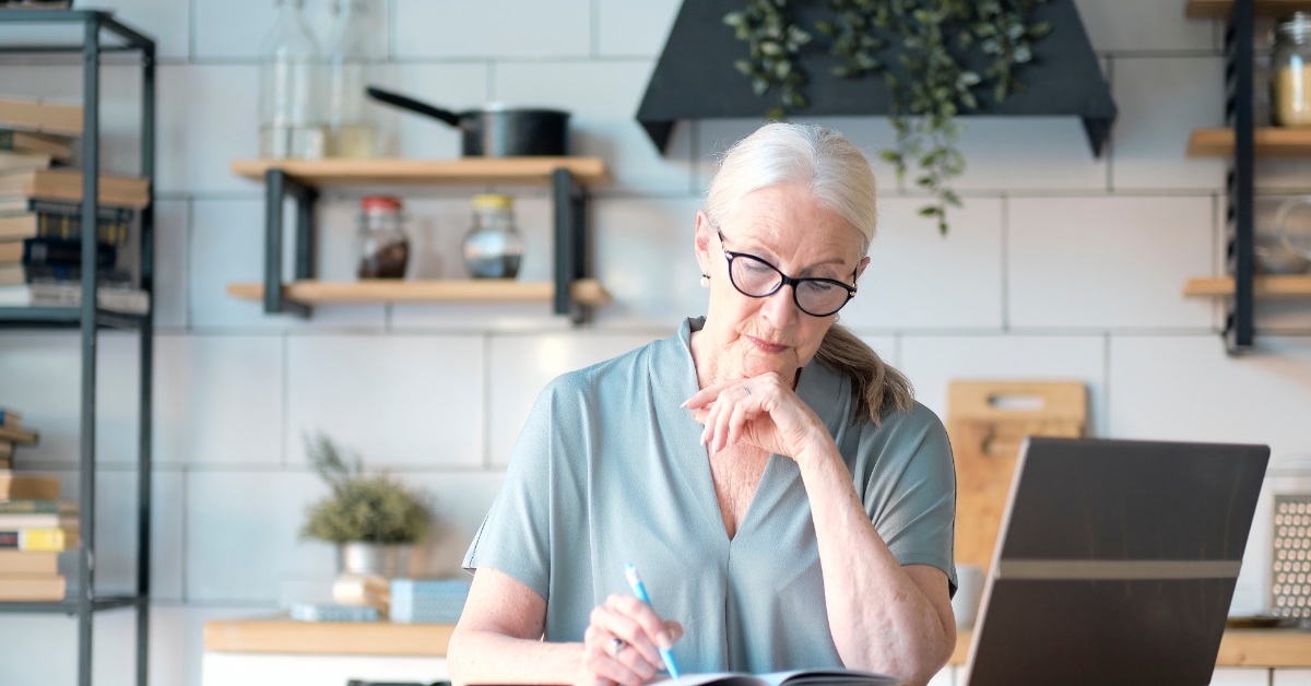senior woman working from home kitchen