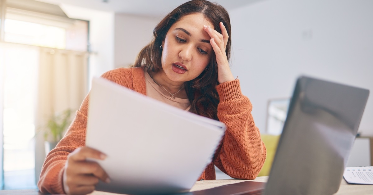 stressed woman reviewing bills at home