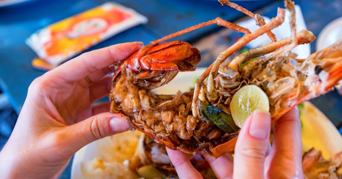 woman eating jumbo lobsters and shrimps