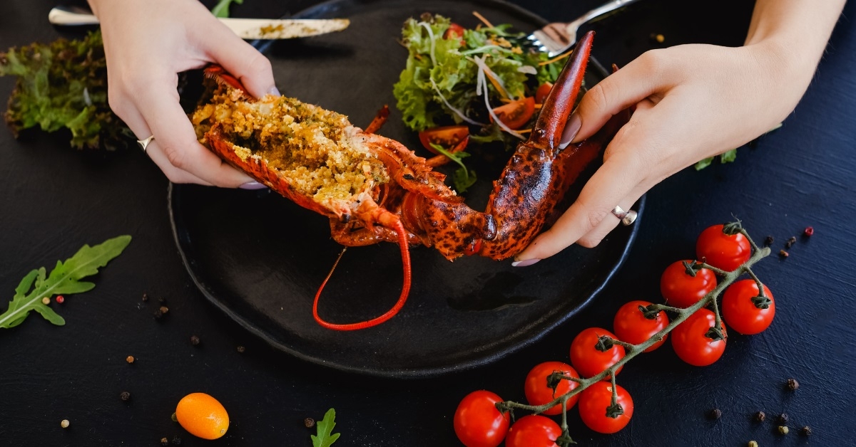 woman holding restaurant stuffed lobster dish