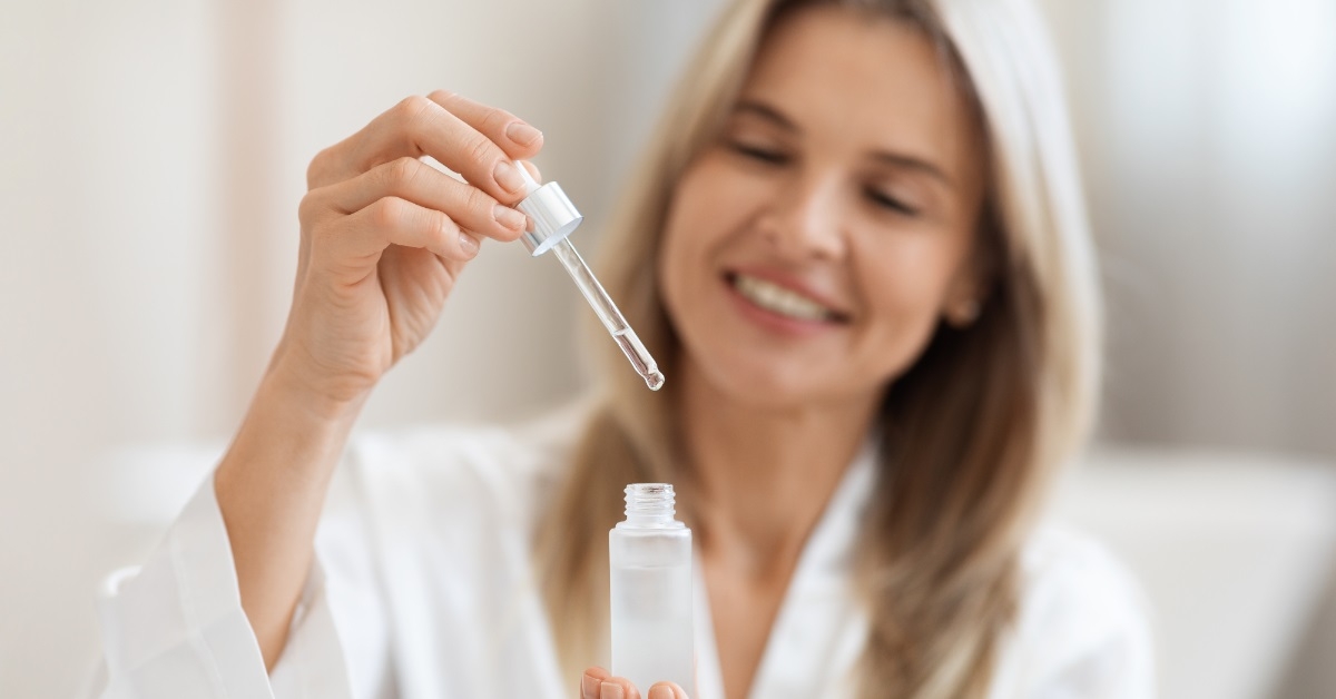 beautiful woman holding skin care product
