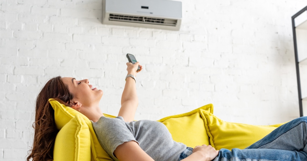 woman relaxing under air conditioner