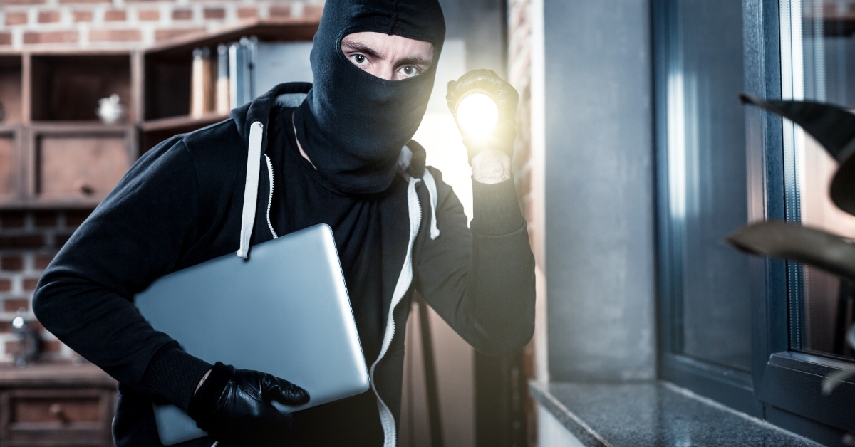 masked criminal stealing laptop