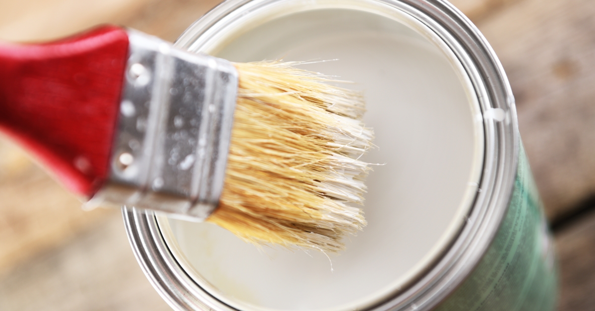 brush dipped in a jar with paint