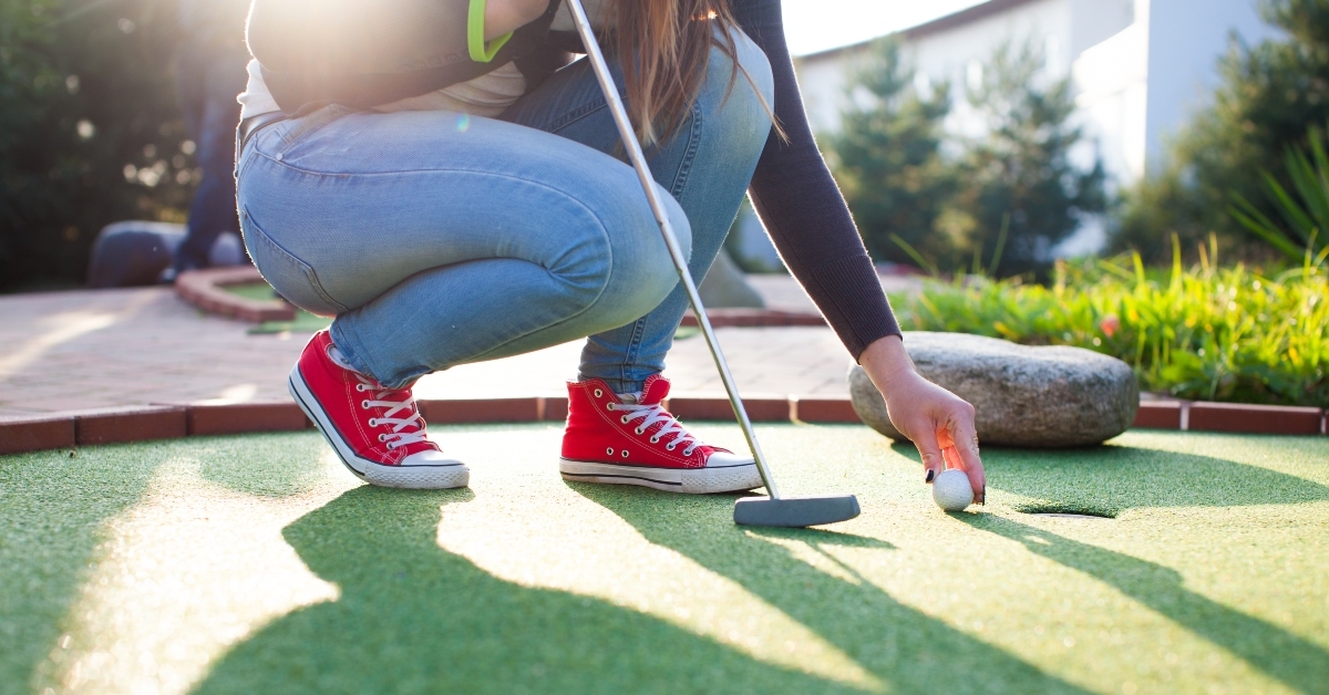 woman plays adventure mini golf
