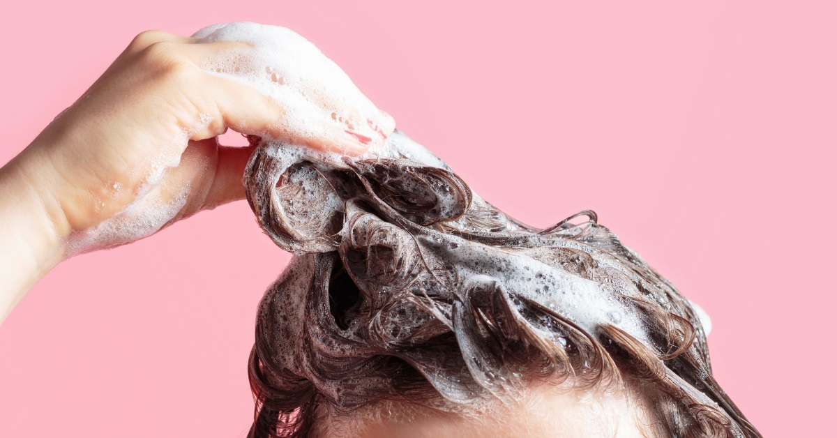 woman washing hair over pink background
