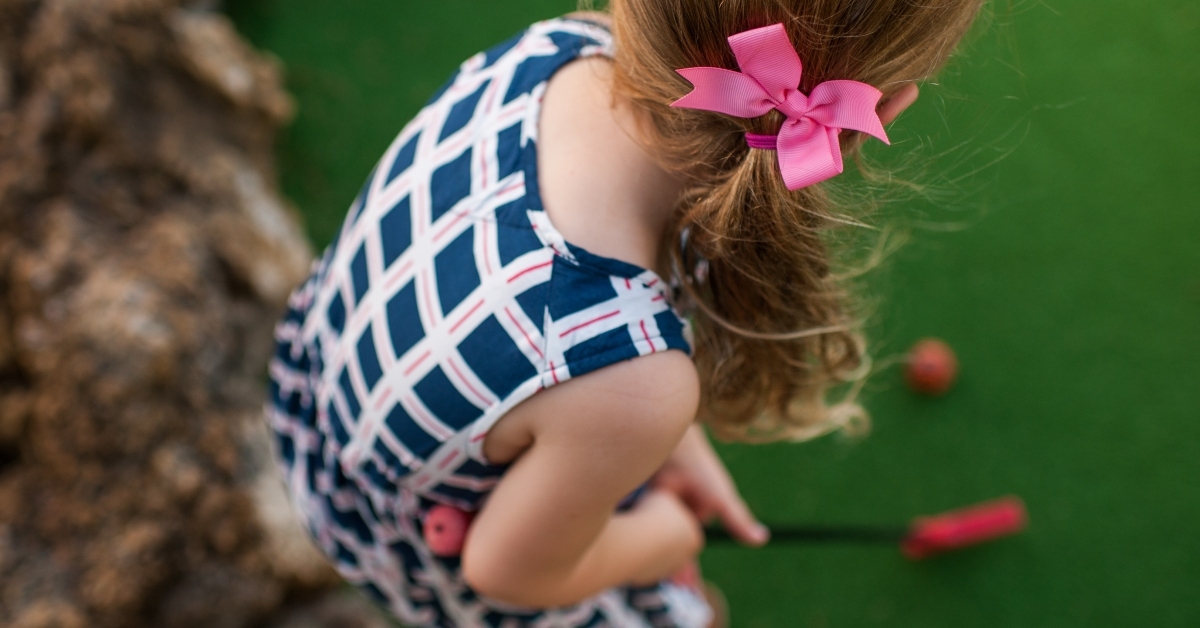 girl playing putt mini golf